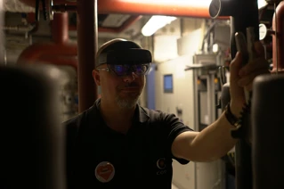 En mann med VR-briller i et dårlig belyst rom