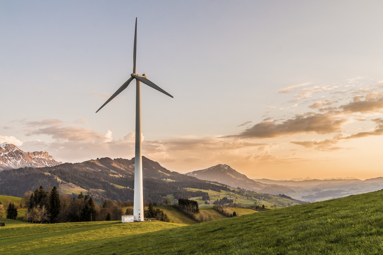 En enslig vindmølle i et vakkert fjell- og åslandskap | Bærekraft gjennom virksomhetsansvar | Coor
