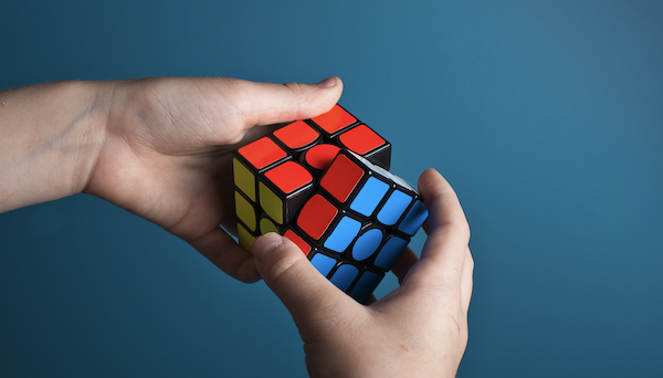 En person er i ferd med å løse rubiks kube | Vi løser alle sider av sosialt ansvar | Coor
