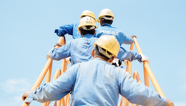 Fire arbeidere med hjelm går opp en trapp | Vi tar sosialt ansvar på alvor | Coor