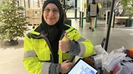 Renholder som viser frem en ipad med renholdsdata