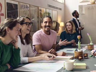 Kollegaer som sitter rundt et bord og drikker kaffe og prater