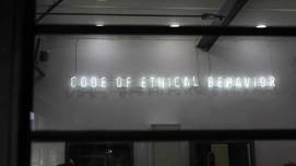 Neonskilt på vegg med skriften code of ethical behaviour