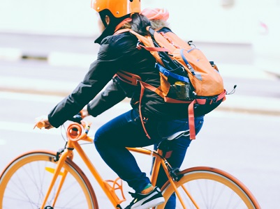Dame sykler på en oransjefarget sykkel | Coor