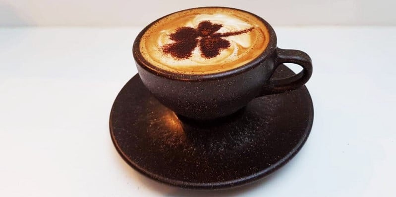 En kopp kaffe med kløverdesign  | Coor
