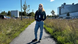 Person som står på en gangsti omgitt av planter