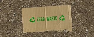 En lapp i papp som ligger på bakken med teksten: Zero waste