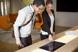 To personer som står og ser på et smart display