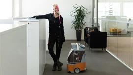 Renolder som poserer sammen med en renholdsrobot